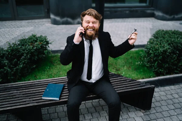 Veselý Mladý Muž Slavnostním Oblečení Vousy Brýlemi Mluví Telefonu Směje — Stock fotografie