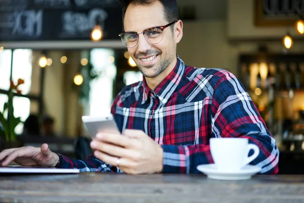 Brunette Mann Briller Rutete Skjorte Moderne Restaurant Med Kopp Tekstmeldinger – stockfoto