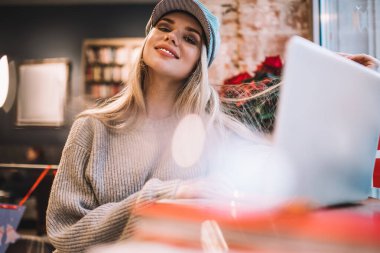 Moda şapkalı mutlu kadın serbest yazar portresi dijital dizüstü bilgisayarla birlikte oturmuş web tasarımı yaratıyor, modern netbook üzerinde çalışan neşeli yenilikçi kız internetle bağlantılı.