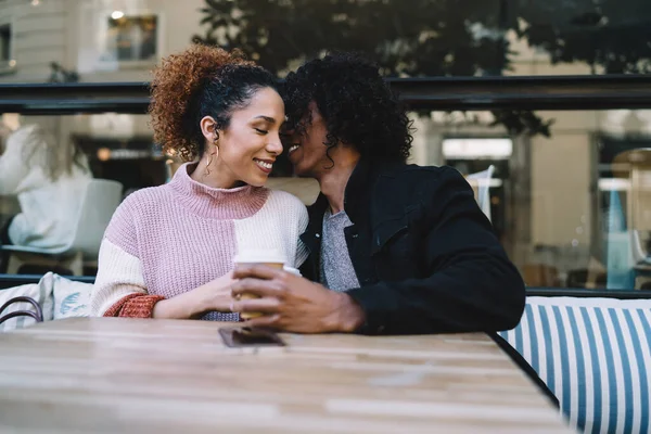 陽気な多様な若い男と女でカジュアル服イチャイチャで目を閉じます日付に座っている間にコーヒーとテーブルで屋外カフェ — ストック写真