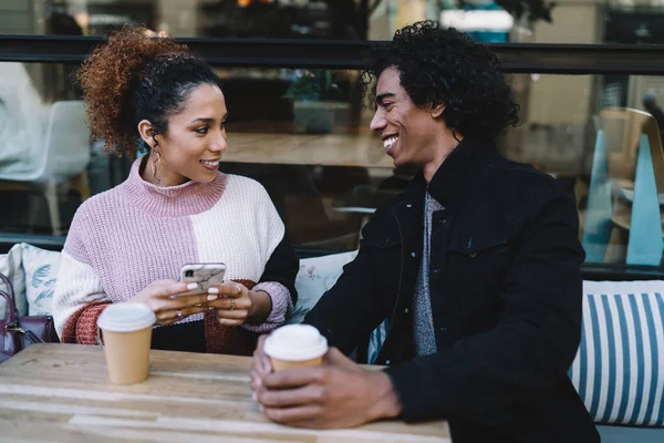 ストリートカフェでコーヒーを飲みながら 明るく多人種の若い男性と女性が笑顔でお互いを見ている — ストック写真