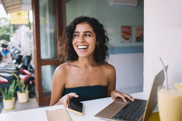 Šťastná Mladá Hispánská Žena Směje Dívá Pryč Při Použití Smartphone — Stock fotografie