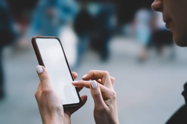 Güzel manikürlü genç bir kadın güpegündüz temiz havada vakit geçirirken cep telefonuna mesaj yazıyor.