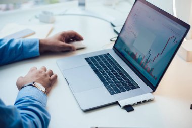 İş adamı, yeni iş stratejisi projesi ve işyerindeki kripto piyasa büyümesi için finansal belgenin dizüstü istatistikleri üzerinde çalışıyor ve analiz ediyor