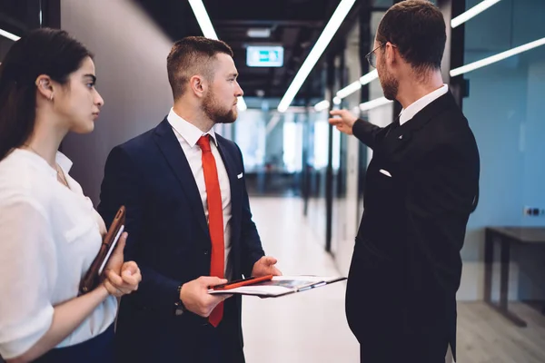 Grupp Seriösa Olika Affärspartner Formella Kläder Som Står Korridoren Innehar — Stockfoto