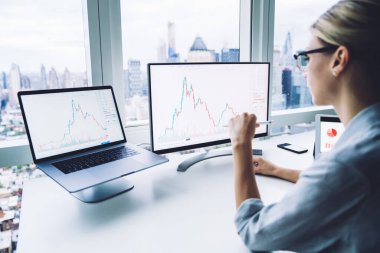 Modern ofiste kripto para birimi bitcoin grafiğiyle çalışan resmi giyimli ve gözlüklü ciddi kadın girişimcilerin geçmişe bakış