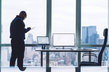 Modern ofiste kripto para birimi bitcoin grafiği ile çalışırken, gözlüklü tanınmayan erkek çalışanın tableti taramasının arka planı