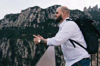 Mutlu sakallı bir erkek sırt çantasının manzarası yüksekte dikilip, bakışlarını kaçırırken resimli dağların tadını çıkarıyor ve İspanya 'da vakit geçiriyor.