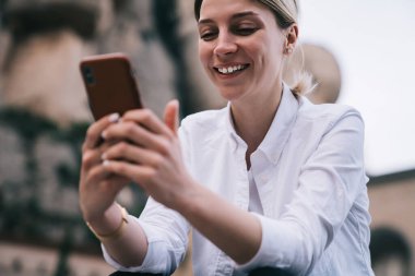 Arkadaşlarıyla akıllı telefondan mesajlaşan ve İspanya 'da vakit geçirirken tek başına dinlenen dişili dişilerden.