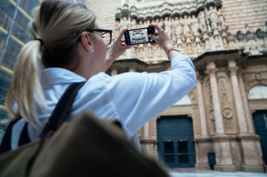 İspanya 'da tatilini geçirirken tarihi katedralin fotoğrafını çeken tanınmayan sırt çantalı bir kadın.