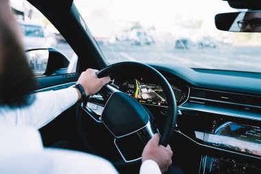 Bulanık caddede işe giderken sürücü koltuğunda oturan mahsul erkek yöneticisinin yan görüntüsü