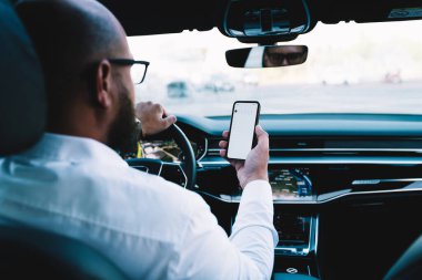 Zarif kıyafetli isimsiz işadamının arka planda cep telefonundan bilgi okurken New York 'ta arabada vakit geçirirken