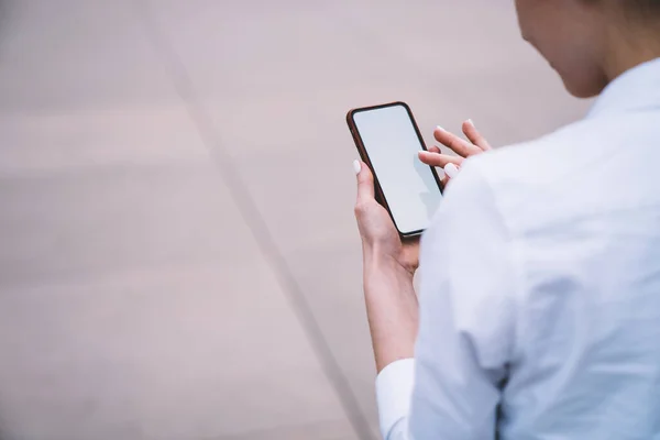 白いマニキュアを持つ顔のない女性のバックビュー市内の夏の日に散歩中に携帯電話のタッチスクリーンをタップ — ストック写真