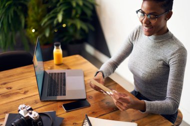 Günlük giysiler ve gözlüklerle tarla işçisi yukarıdan masaya oturup kahve molasının keyfini çıkarırken zarfı mühürlüyor.