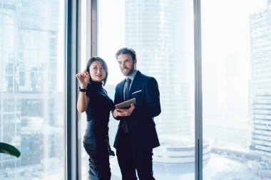 İş toplantısı sırasında kurumsal yenilikler hakkında konuşan çok kültürlü ofis çalışanları, şirket ofislerinde finans ve ticaret hakkında iletişim kuran başarılı erkek ve kadın profesyonel uzmanlar