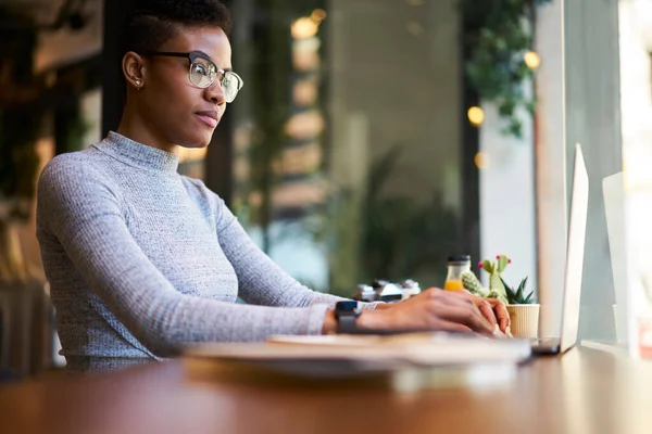 Vista Lateral Mujer Negra Pensativa Sentada Escritorio Mientras Busca Información — Foto de Stock