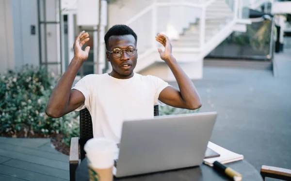 Seriöser Junger Afroamerikaner Freizeitkleidung Und Brille Arbeitet Mit Laptop Tisch — Stockfoto