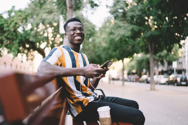 Χαρούμενος Αφροαμερικανός Νεαρός Άνδρας Casual Ρούχα Χαλαρώνοντας Στο Παγκάκι Του — Φωτογραφία Αρχείου