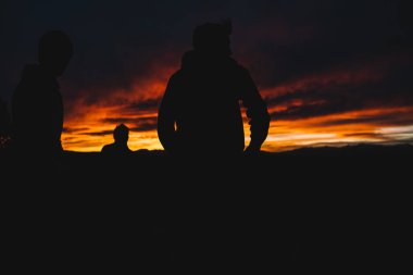 Vadide duran gezginlerin siluetlerinin muhteşem manzarası ve sıcak yaz akşamlarında kırsalda muhteşem günbatımına hayran olmak.