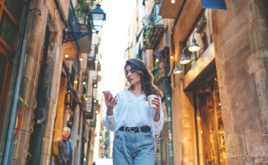 Kafkas kadın turist seyahat sırasında akıllı telefon konumunu kontrol ediyor. Kulaklıklı 4G ile gezen, milenyum kızı seyahat şehrinde cep telefonu sohbetleri sırasında sesli mesaj alıyor.