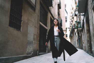 Siyah ceketli genç bayanın boş caddeye çıkıp kameraya gülümsediği bir fincan kahve içmesinden.