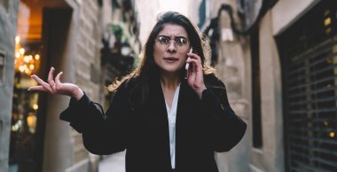 Görme düzeltmesi için optik gözlüklü kafası karışmış hippi kızın yarım boy portresi gezi gezintisi sırasında sorunları çözüyor, danışmanlık için cep telefonunu kullanan gözlüklü kayıp kadın turist.