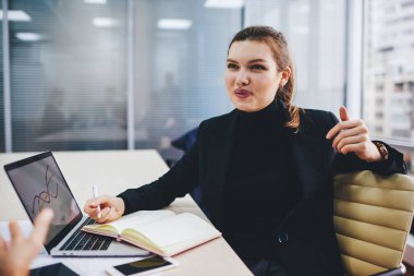 Resmi kıyafet giymiş başarılı bir kadın çalışan işten çıkarılmış iş arkadaşlarıyla gelir kriterlerini tartışıyor, dizüstü bilgisayarı planlayan kendine güvenen işadamları masaüstünde oturuyor ve pazardan bahsediyor.
