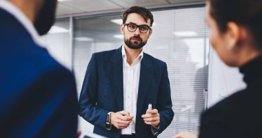 Resmi giyinen erkek tüccar, iş dünyasının üretken stratejisi için profesyonel iş arkadaşlarıyla, yürütme yöneticileriyle ofis içi projesinde işbirliği yapma konusunda tartışıyor.