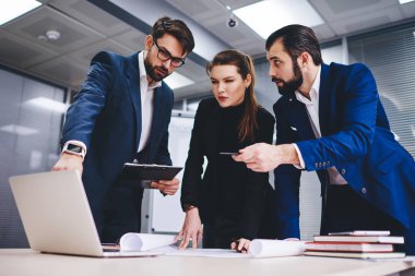 İş ortaklarının ortak şirket projesini tartıştığı ortak süreç, erkek ve kadın girişimcilerin video izlemek için dizüstü bilgisayar kullanarak plan çizimleri üzerinde işbirliği yapmaları