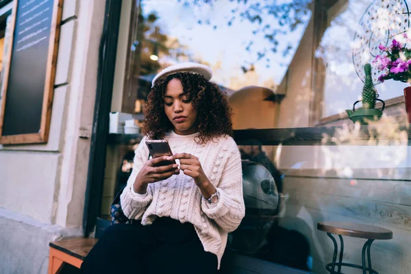 Pensiv Mörkhyad Lockig Kvinna Som Använder Smartphone För Att Läsa — Stockfoto