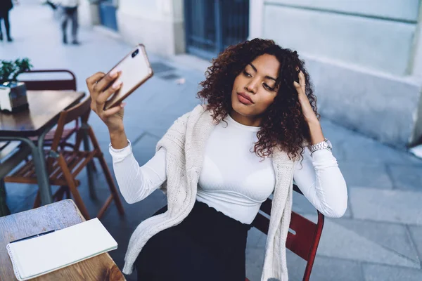 Vacker Mörkhyade Kvinnliga Influencer Sitter Utomhus Café Terrass Med Mobiltelefon — Stockfoto