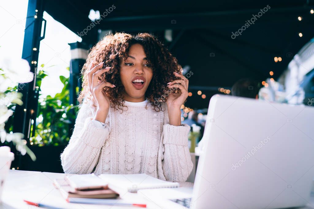 Emotional dark skinned hipster girl feeling irritation about trouble with software on laptop computer during remote job, expressive angry african american woman freelancer stressed with troubles
