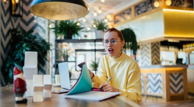 Kafası karışmış göz elbiseli bayan öğrenci bilgi kitaplarından bilgi topluyor tavan arası kafeteryasında öğrenme sırasında yapılan proje hatalarından dolayı şok geçiriyor, kapalı alanda okuyan Kafkasyalı öğrenci hayrete düşüyor.