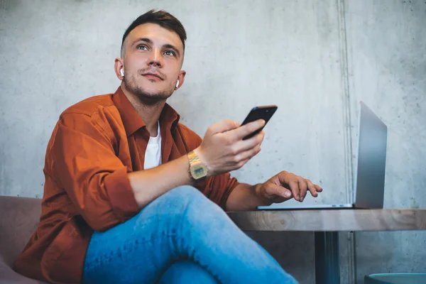 Enger Junger Mann Freizeitkleidung Mit Smartphone Der Hand Sitzt Tisch — Stockfoto