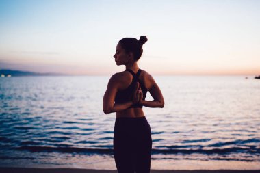 Huzurlu deniz ufkunda Asya manzaralı deneyimli bir kadın. Uyumun tadını çıkarıyor. Meditasyon yoluyla aydınlanma arayan esnek bir kadın.