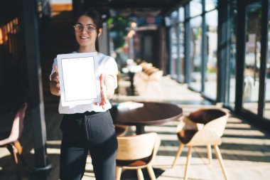 Kafeterya 'nın varlıklı, neşeli kadın portresi. Boş ekranlı dijital tablet, refah içinde esmer kadın dokunmatik dokunmatik ekranlı, sahte monitörle kariyerinin tadını çıkarıyor.