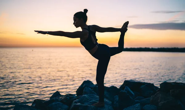 在大自然的海滩上练习平衡的同时做瑜伽的女运动员Natarajasana Asana在享受时间的同时 — 图库照片