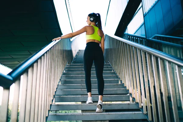 Вид Сзади Красивую Стройную Женщину Активной Одежде Стоящую Лестнице Слушающую — стоковое фото