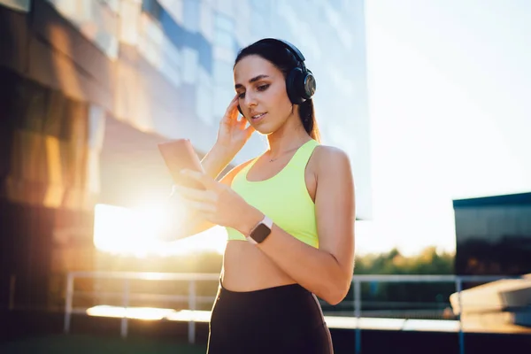 Şık Aktif Giyimli Düşük Açılı Atletik Kadın Akıllı Telefon Kullanıyor — Stok fotoğraf