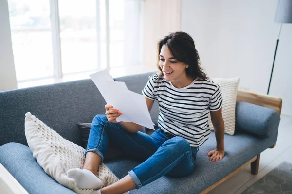 Joven Mujer Alegre Ropa Casual Sentada Acogedor Sofá Casa Sonriendo —  Fotos de Stock