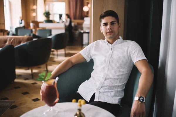Gündelik Kıyafetli Genç Adam Masada Kokteyl Içerek Rahatlıyor Modern Restoranda — Stok fotoğraf