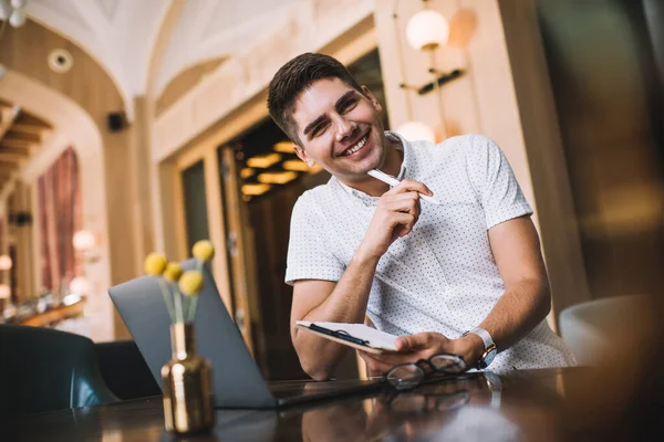 Van Onderen Van Vrolijke Jonge Man Zitten Moderne Werkplek Houden — Stockfoto