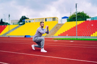 Aktif giyimde ciddi derecede güçlü bir erkek aktif yaşam tarzı ve canlılığından tatmin olmuş kasları eğitiyor. Kararlı bir adam kilo veriyor ve kardiyo egzersizinde mükemmel vücut şekli okuyor.