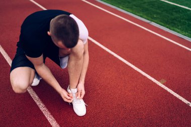 Aktif çalışan beyaz erkek koşucu yeni koşu ayakkabıları giyiyor. Kardiyo antrenmanına başlamak için. 20 'li yaşlarda güçlü bir sporcu.