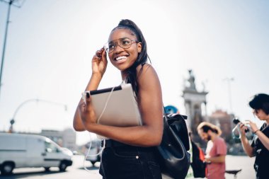 Neşe dolu, tabletli genç bir bayanın şehrin etrafında dolaşırken sokakta trafik işaretini beklemesi.