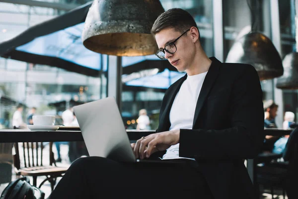 Konzentrierter Junger Mann Formalem Anzug Und Brille Sitzt Mit Laptop — Stockfoto