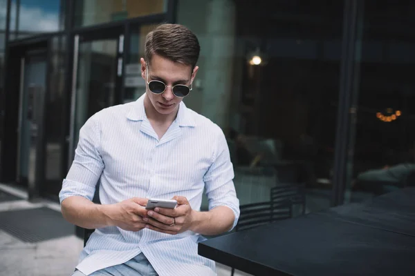 Giovane Uomo Concentrato Abiti Casual Occhiali Sole Utilizzando Smartphone Mentre — Foto Stock