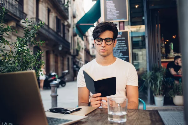 Focalizzato Casuale Maschio Intelligente Occhiali Libro Lettura Mentre Seduto Tavola — Foto Stock