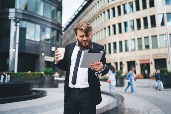 Joven Emprendedor Concentrado Traje Formal Con Barba Mirando Tableta Frunciendo — Foto de Stock