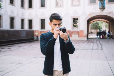 Şehirdeki tatillerde kare üzerinde fotoğraf çekmek için ekipman kullanan yetenekli genç erkek fotoğrafçı, 20 'li yaşlardaki Hintli turist, şehirdeki konum ve durakların fotoğrafını çekiyor ve hobi olarak vakit geçirmekten keyif alıyor.
